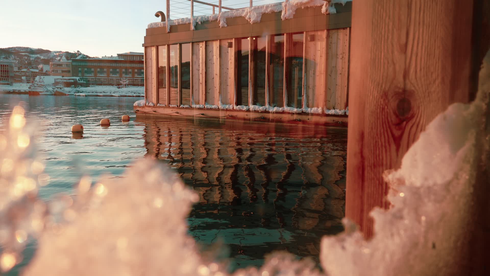 Badstuen fra sjøsiden med snø og bokeh
